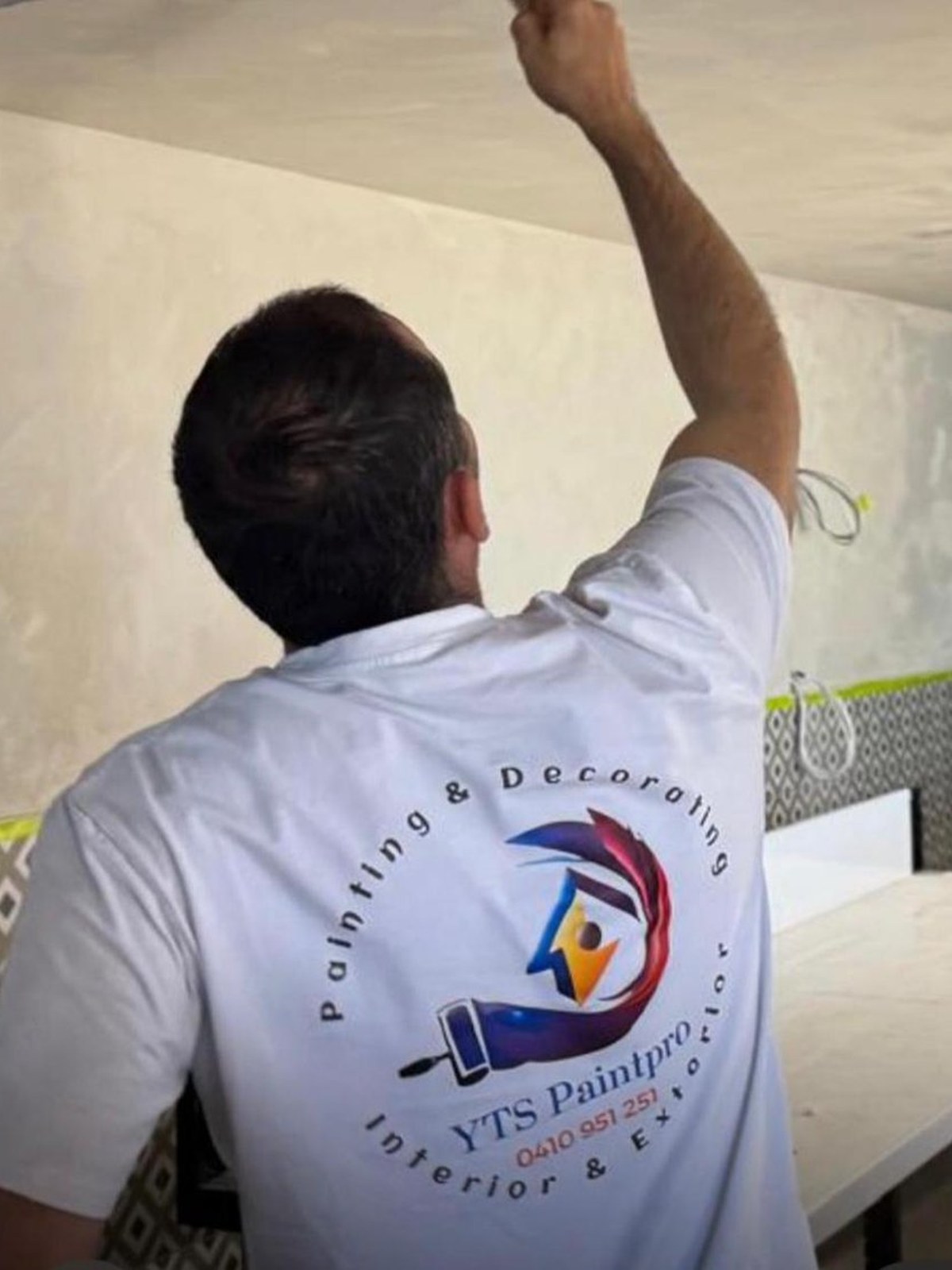 A YTS PaintPro tradesman applying a ceiling finish on site